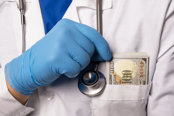 A doctor with money in his labcoat pocket