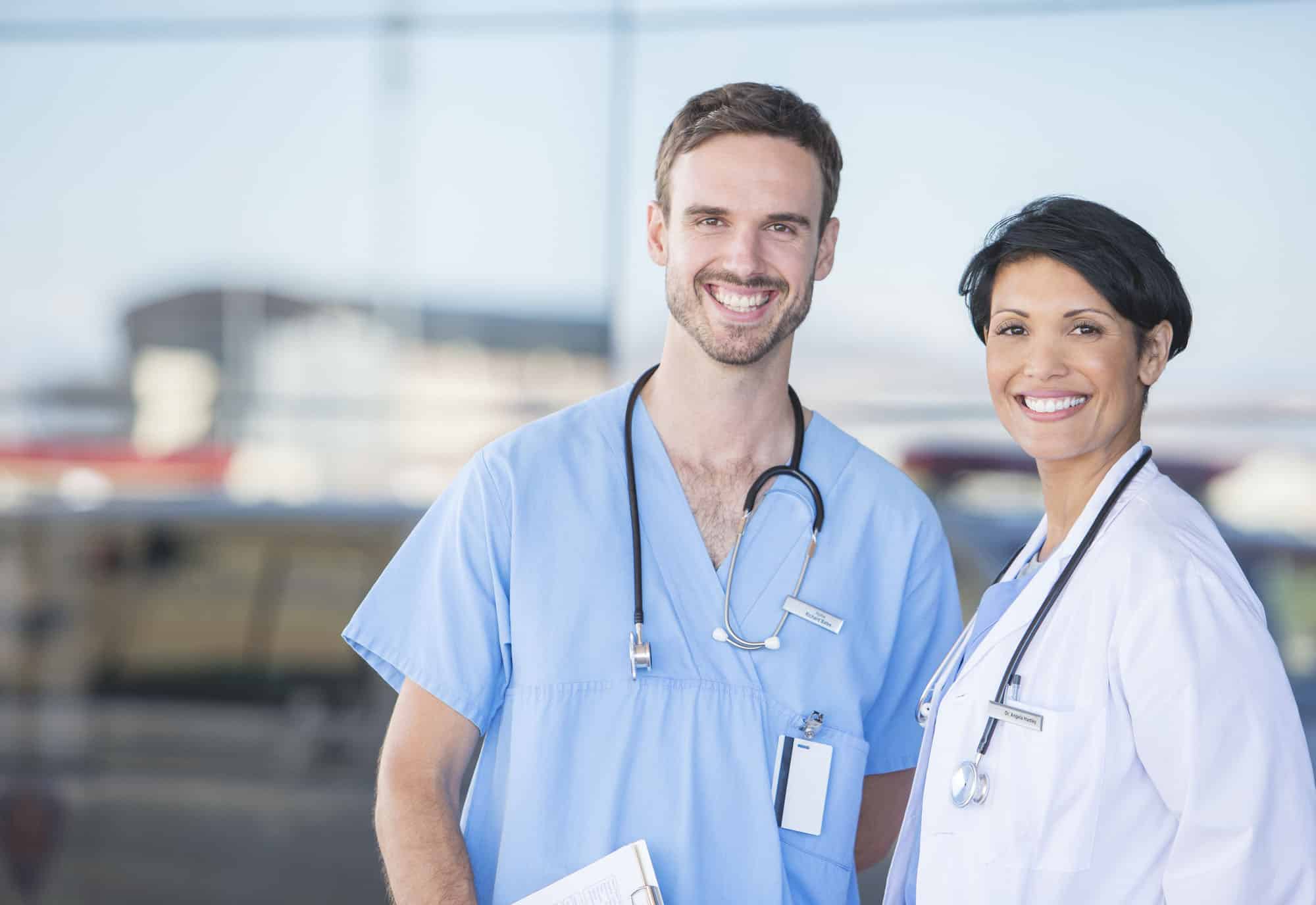 Doctor and nurse smiling outdoors